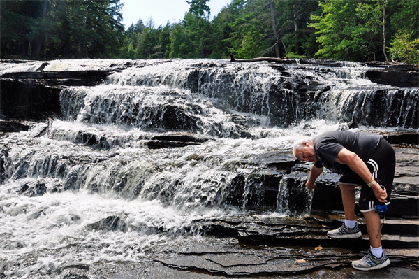 Lee Duquette feeling the water at Nawadaha Falls